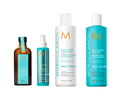 Four Moroccanoil Frizz Control haircare products arranged on a white background: an amber bottle, a turquoise spray bottle, a white bottle, and a turquoise shampoo bottle.