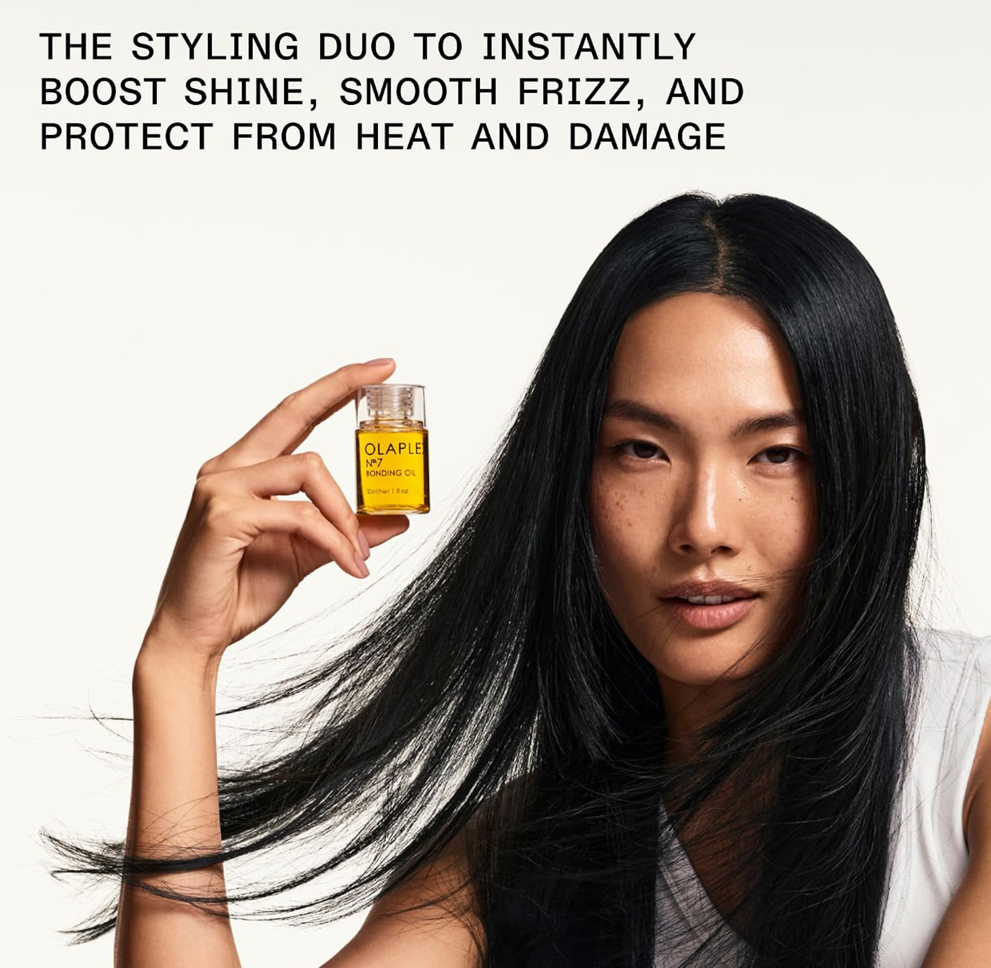 A woman with long, straight black hair holds a small bottle of OLAPLEX hair serum against a clean white background, with promotional text at the top.